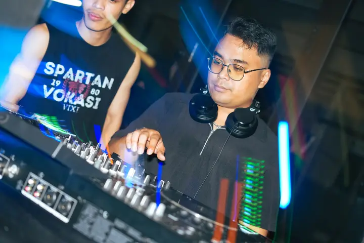 DJ mixing under blue lights at Fresh Start